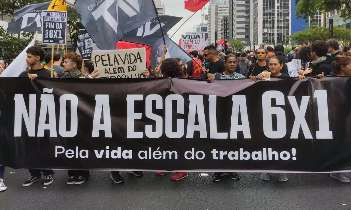 Manifestantes carregam faixa com a mensagem "Não à escala 6x1" durante ato na Avenida Paulista em defesa da redução da jornada de trabalho. Manifestantes carregam faixa com a mensagem "Não à escala 6x1" durante ato na Avenida Paulista em defesa da redução da jornada de trabalho.