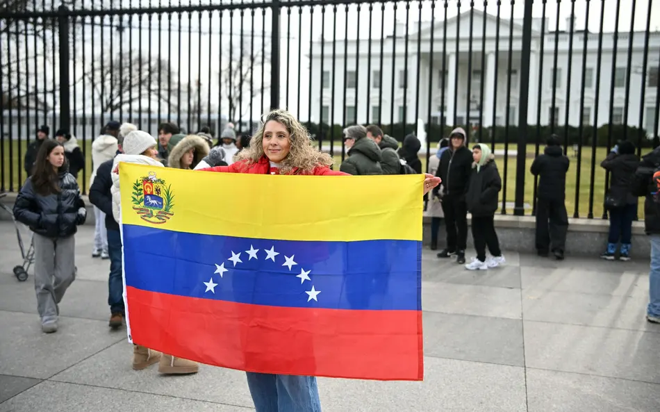 Mulher ergue bandeira venezuela em frente à casa branco foto mandel ngan afp