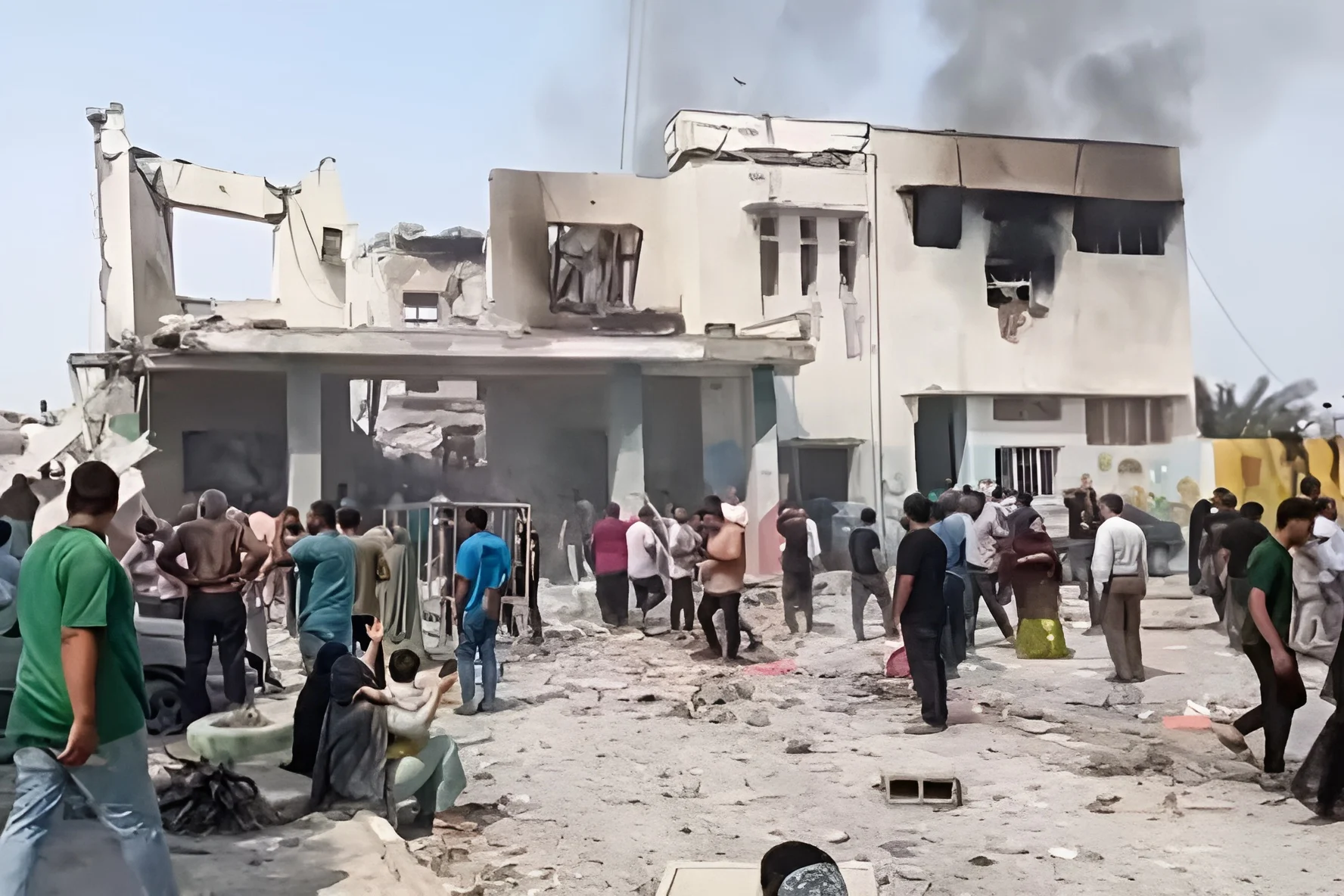 Escola Hormozgan atingida Israel e EUA Ruínas de uma escola atingida por ataques na província de Hormozgan, Irã, com civis observando os danos. A destruição de infraestruturas civis ilustra a crise na geopolítica global e o desrespeito aos princípios do direito internacional.