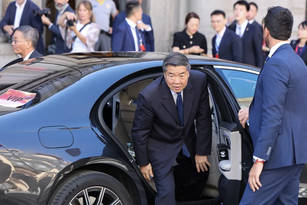 He Lifeng desce de carro oficial cercado por seguranças e autoridades durante evento institucional. A cena ilustra o protagonismo do governo chinês na condução do novo modelo econômico baseado em abertura controlada e livre comércio.