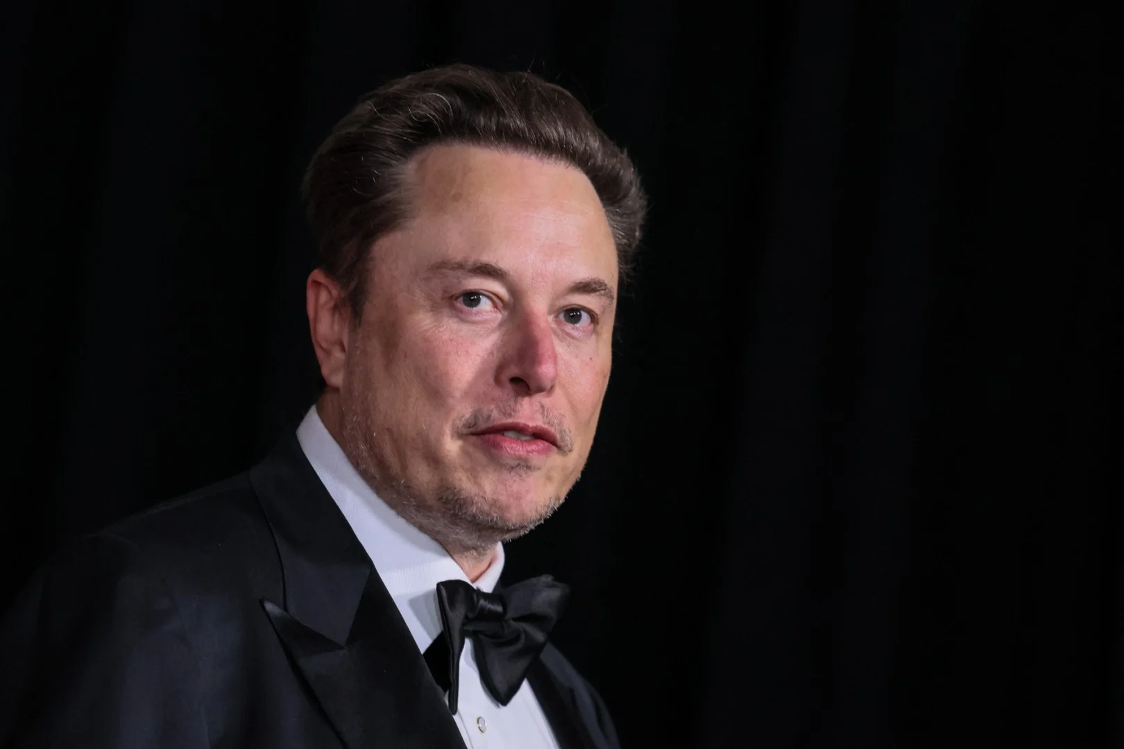 Elon Musk em retrato formal com fundo escuro, associado ao debate sobre o poder das plataformas digitais e conflitos com regulações nacionais na discussão sobre soberania digital.