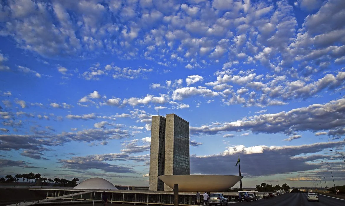 Vista externa do Palácio do Congresso Nacional sob céu azul ensolarado em Brasília.